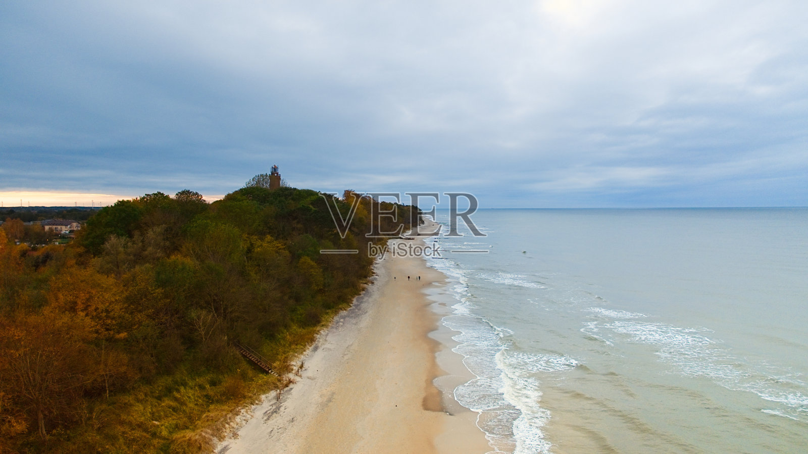 在11月一个多云的日子里，无人机捕捉到Gski灯塔矗立在阴暗的天空中。宁静的大海与温柔的波浪拍打着空旷的海滩，创造了一个宁静的海岸场景，邀请反思和孤独。照片摄影图片