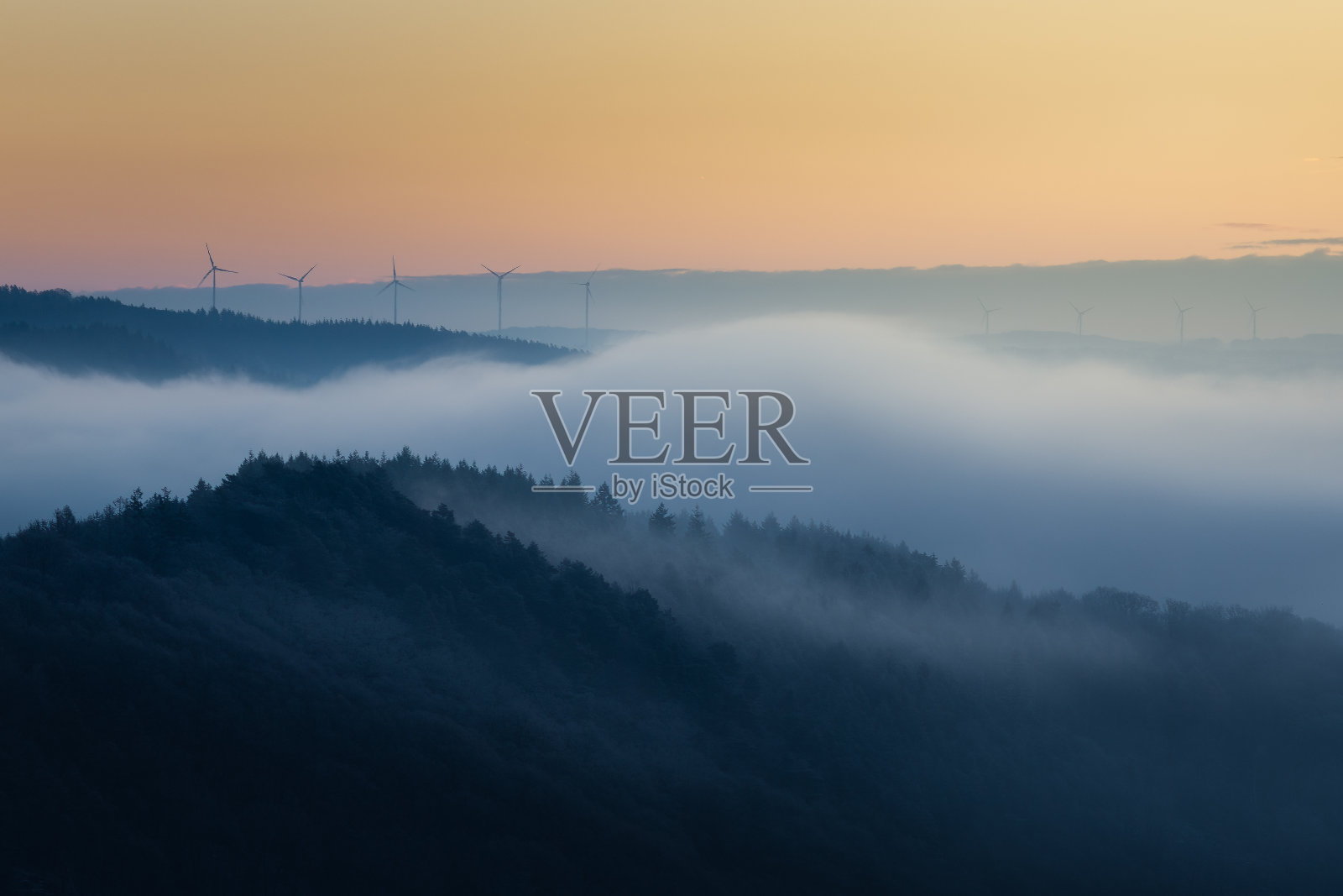 美丽的风景，以日落时的山丘和远处的风力涡轮机为特色照片摄影图片