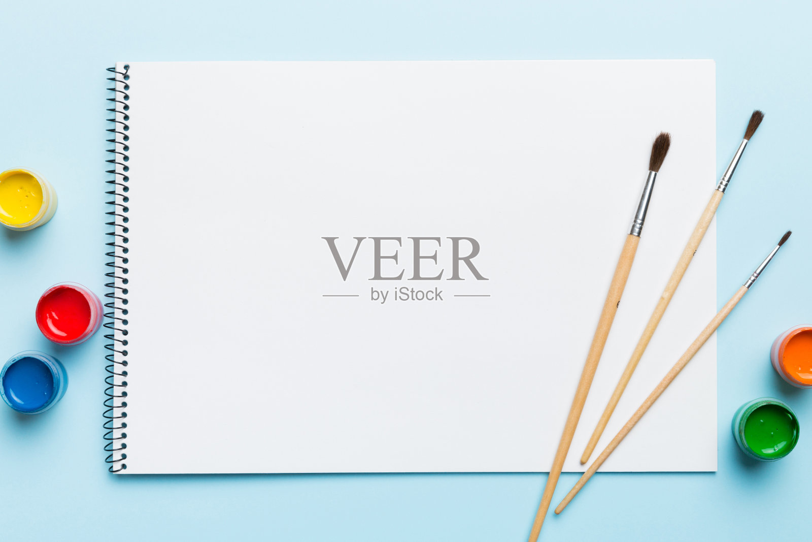 相册页和油漆，铅笔，画笔在彩色的背景。空白处的俯视图。创造的工作场所。家庭教学概念图照片摄影图片