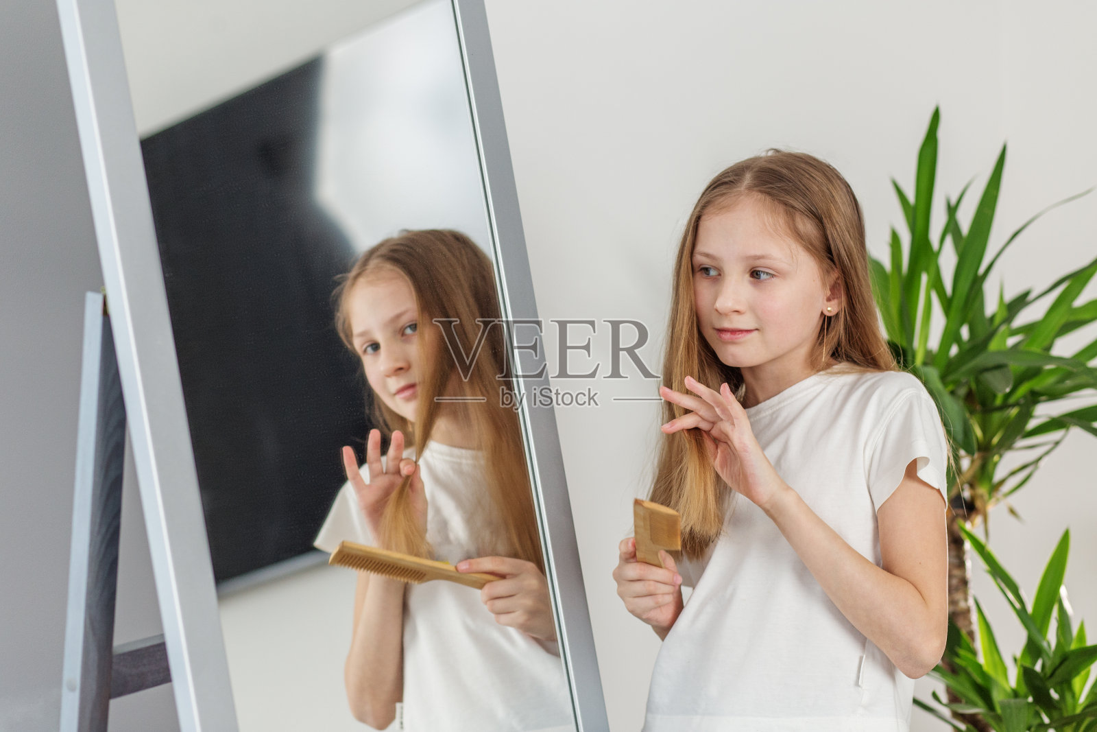 小女孩在镜子里梳头。早上上学前的准备。照片摄影图片