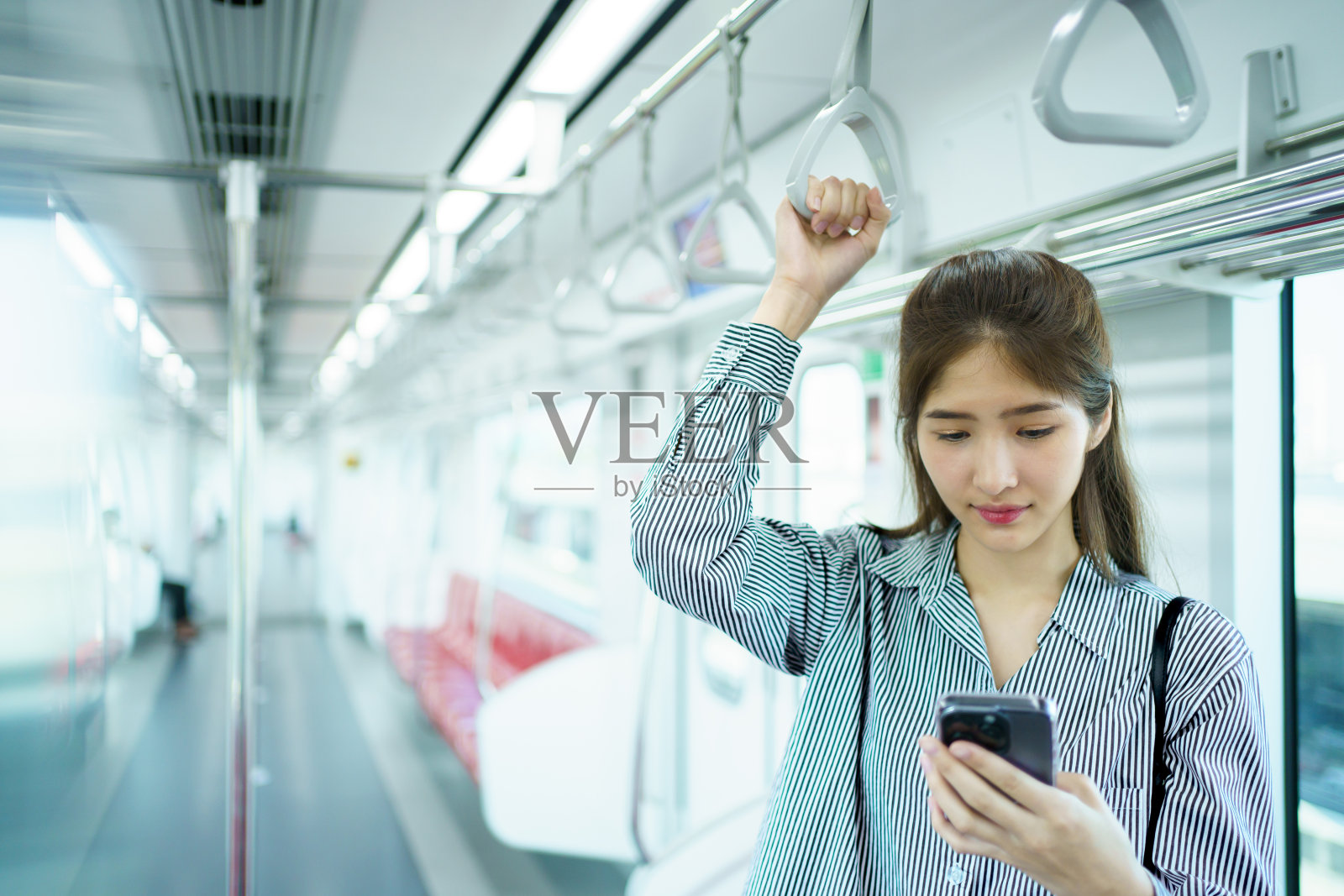 女商人在火车上使用智能手机。照片摄影图片