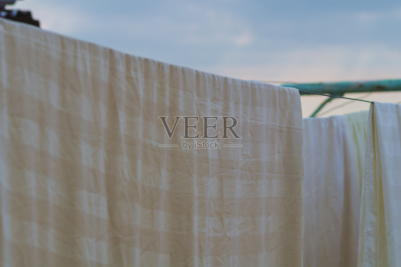 黄白色条纹床上用品洗完后挂在晾衣绳上。这是一个关于家务的概念，有时你无法将自己与之拉开距离照片摄影图片