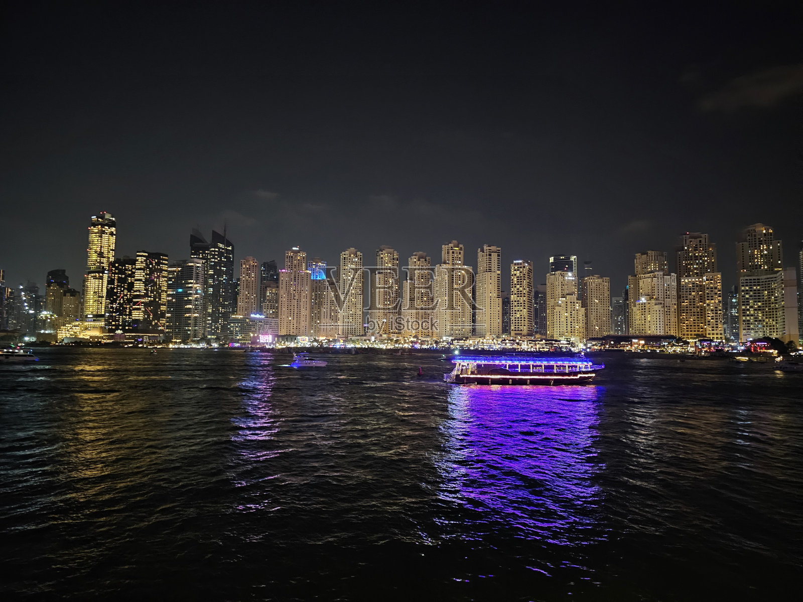 在城市天际线的水中航行的船照片摄影图片