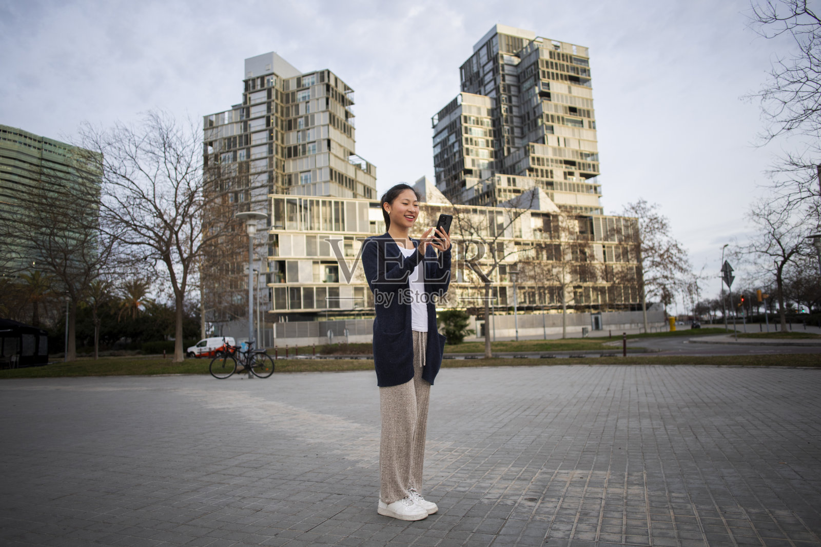 年轻的亚洲女人在用手机照片摄影图片