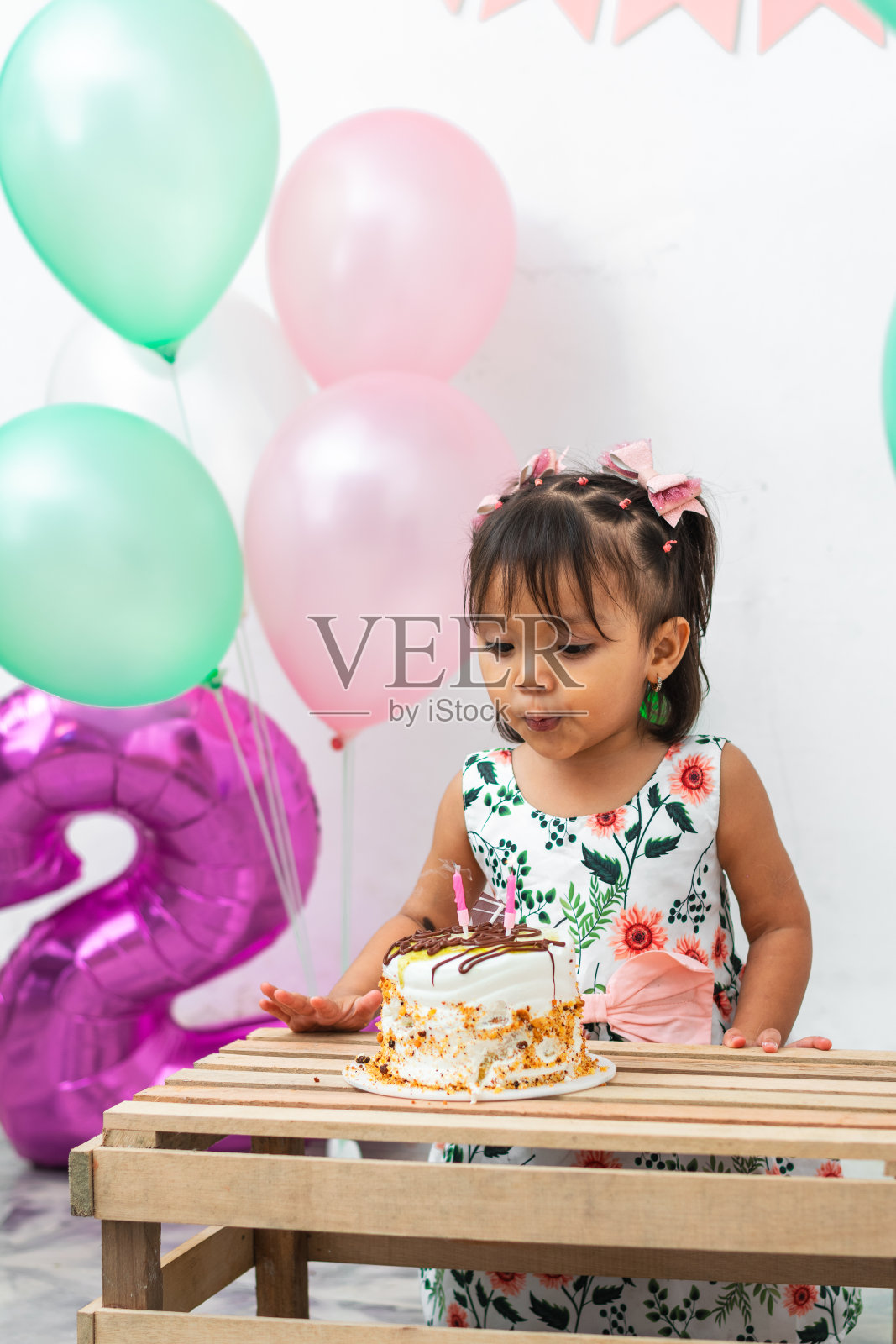 拉丁褐发小女孩在生日那天吹灭了蛋糕上的蜡烛照片摄影图片