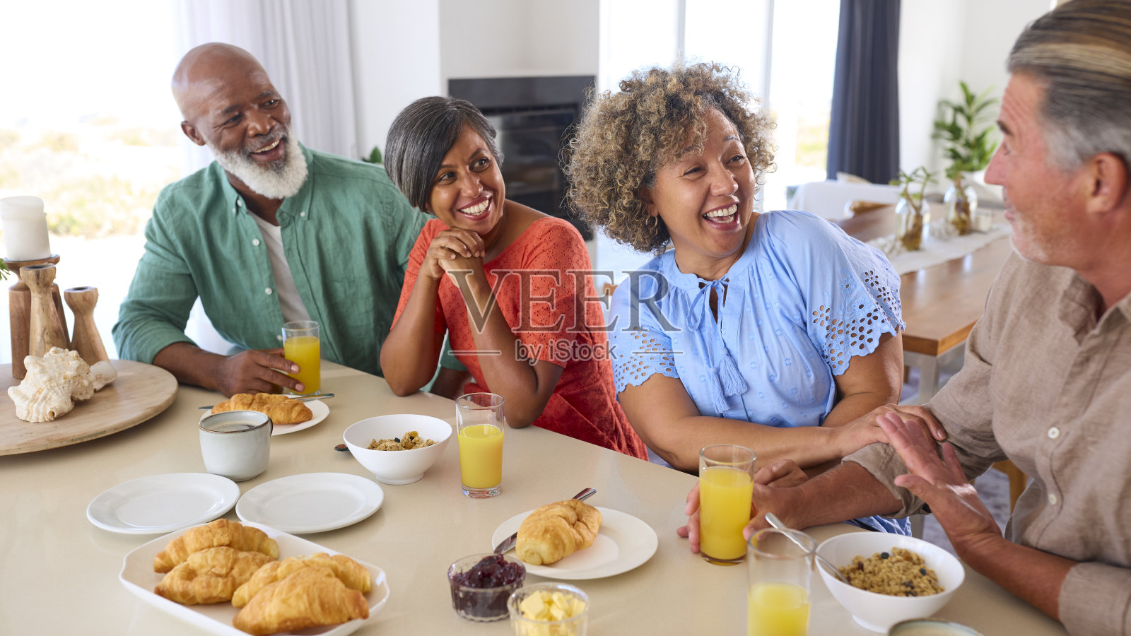 一群微笑的成熟朋友在度假或在家一起吃早餐照片摄影图片