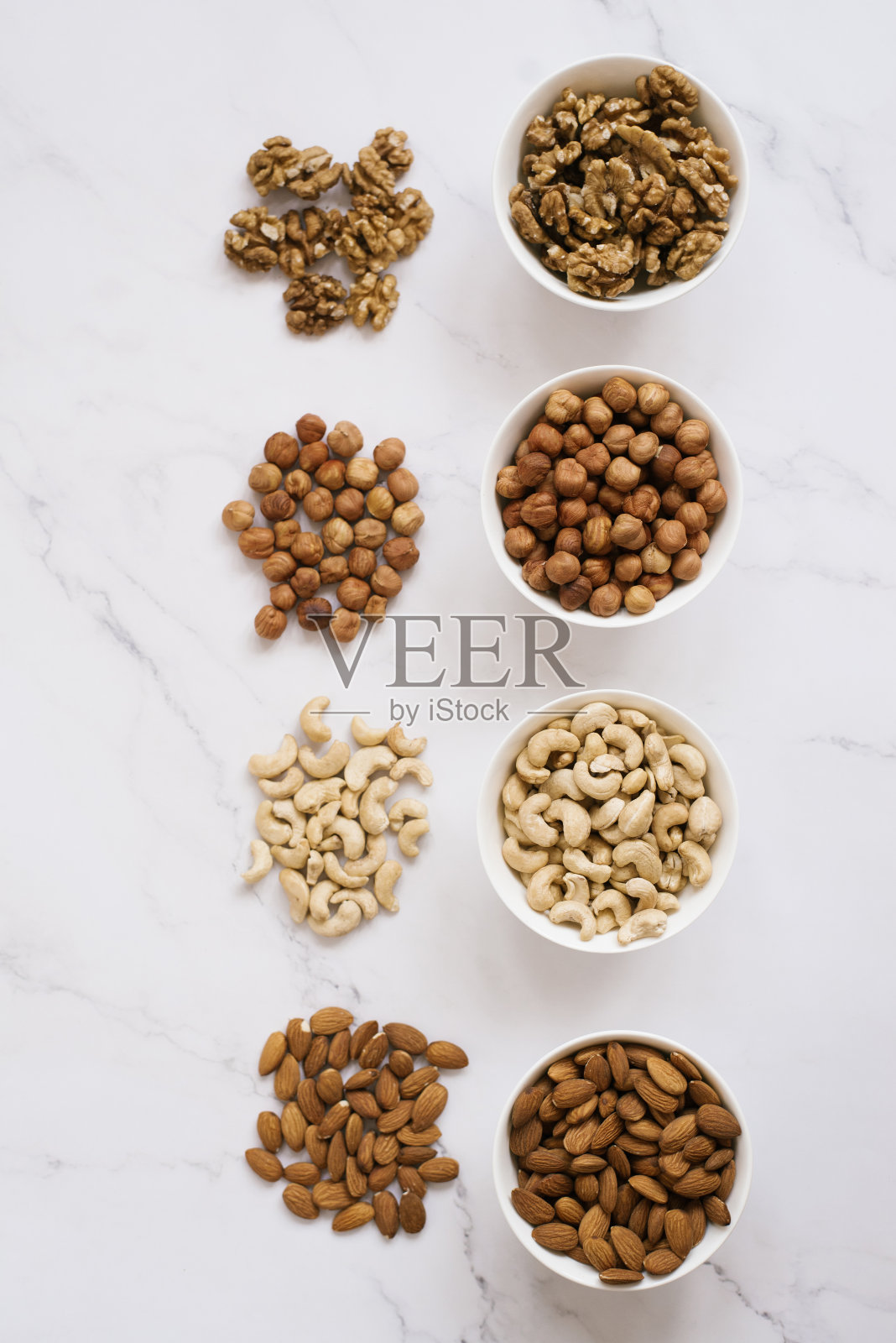 各种坚果和干果放在白色的碗里照片摄影图片