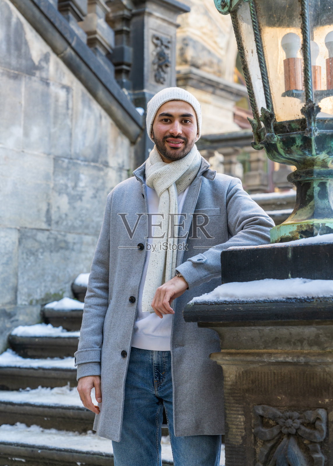 一个穿着浅色外套的时髦亚洲男人站在古老的台阶上。快乐的旅行者看着德国德累斯顿市的旅游景点照片摄影图片