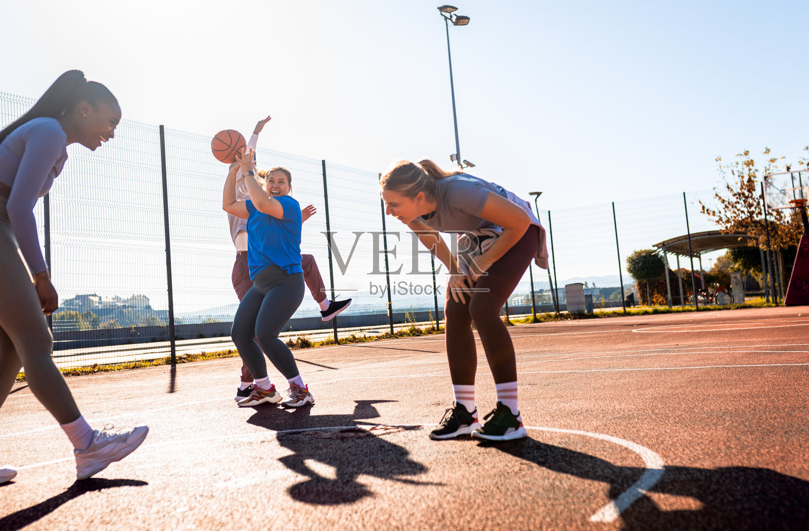 各种各样的年轻女性在户外打休闲篮球。照片摄影图片