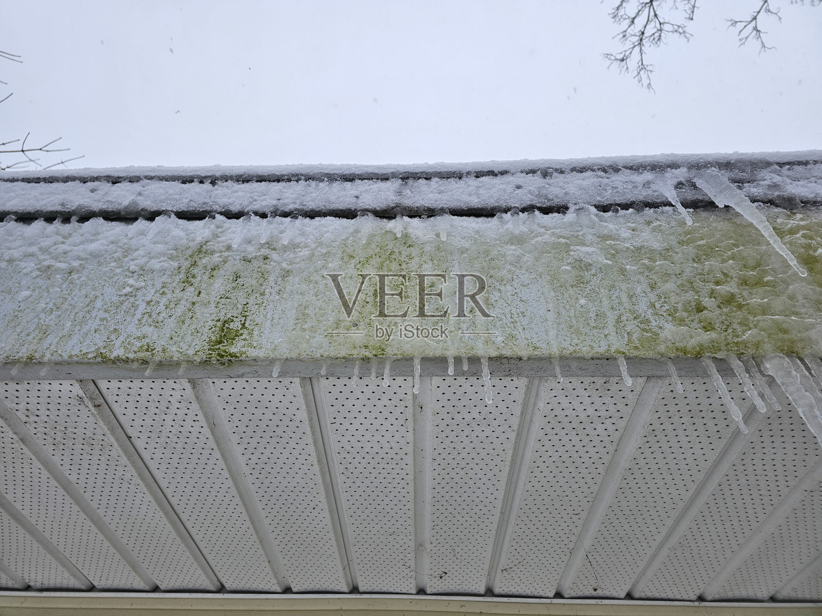 沿着肮脏屋顶的冰柱照片摄影图片