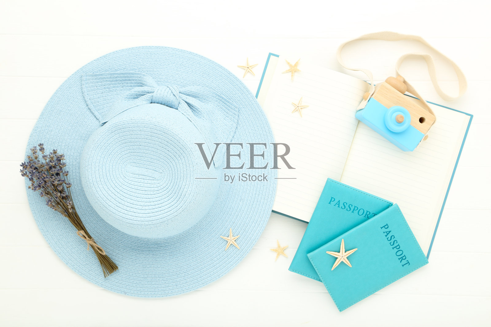 夏日草帽上有薰衣草花，护照，笔记本和海星放在白色木桌上照片摄影图片