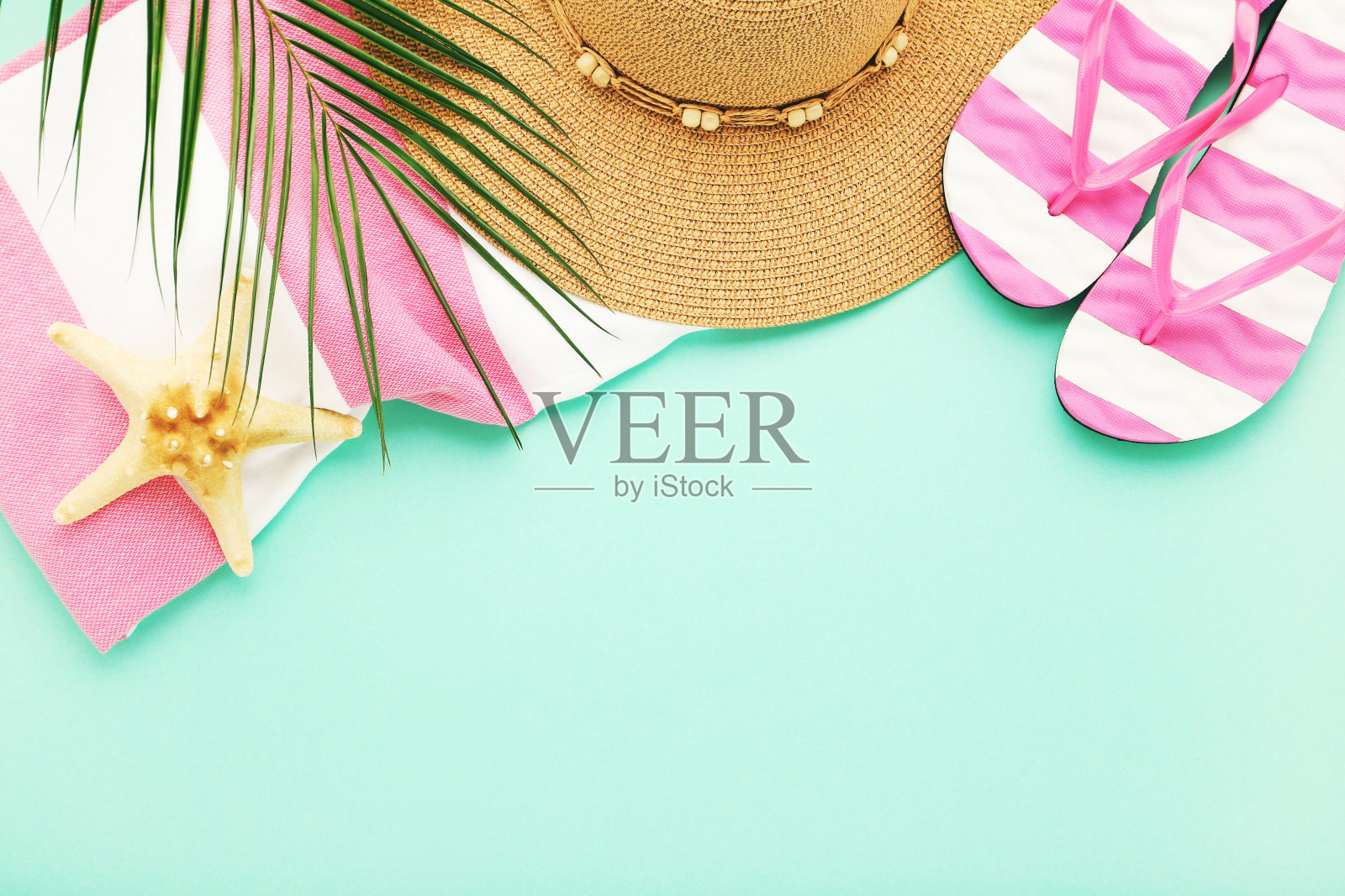 草帽，毛巾，海星和棕榈叶在薄荷背景对人字拖照片摄影图片