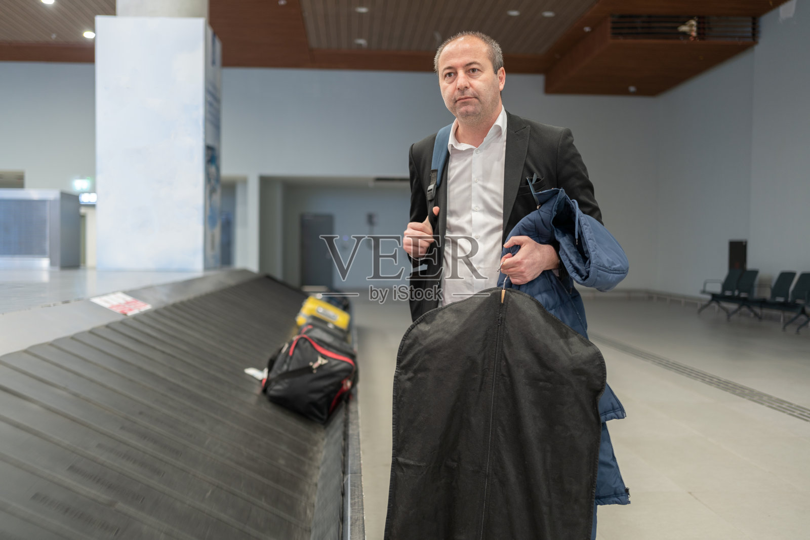 商人在机场等行李照片摄影图片