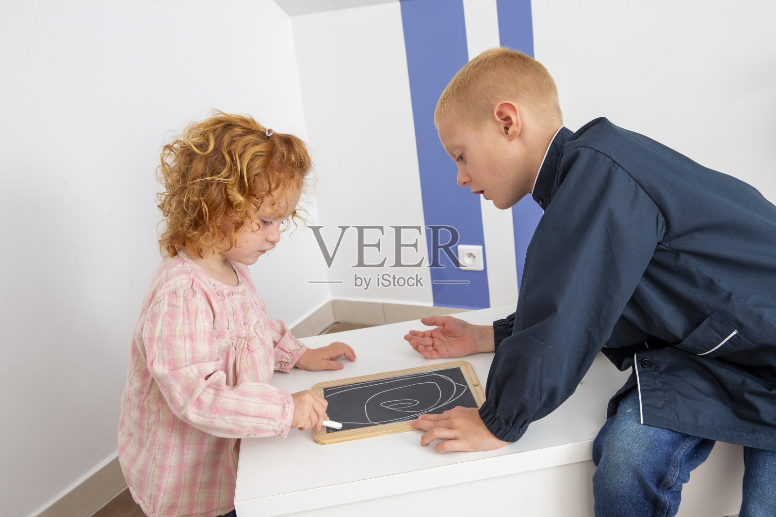 一个小男孩和一个小女孩在画画照片摄影图片