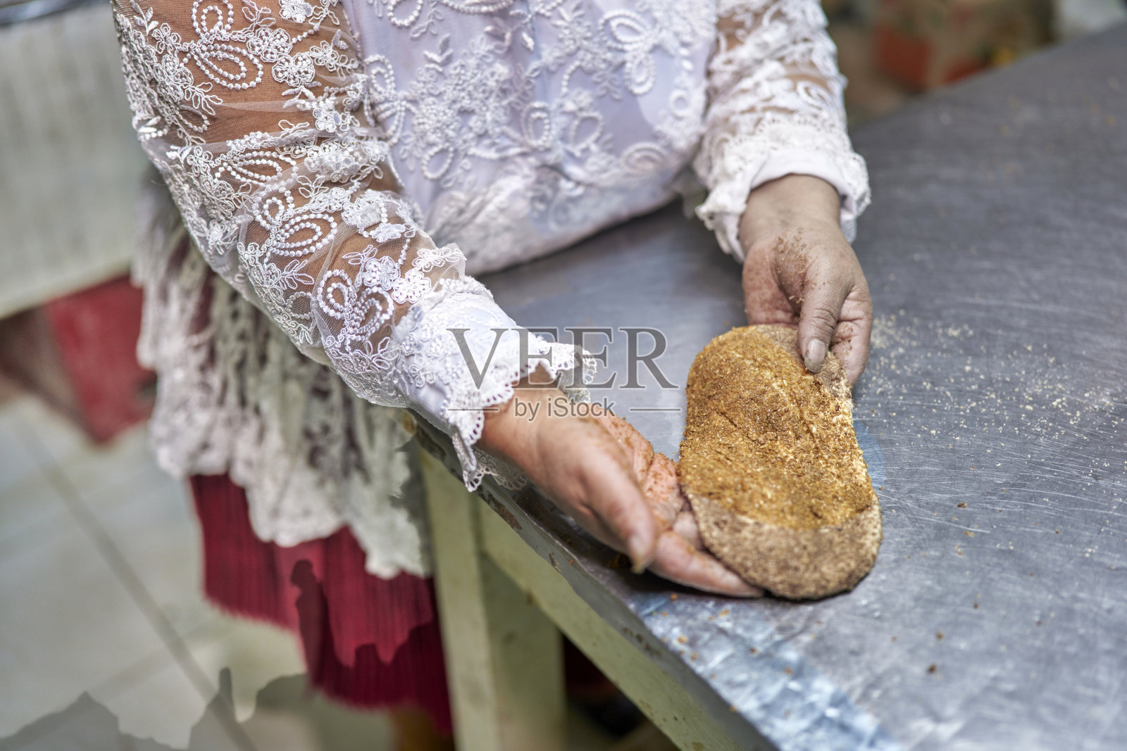 一位来自秘鲁小镇Oropesa的面包师正在用手揉面团制作chuta面包。照片摄影图片