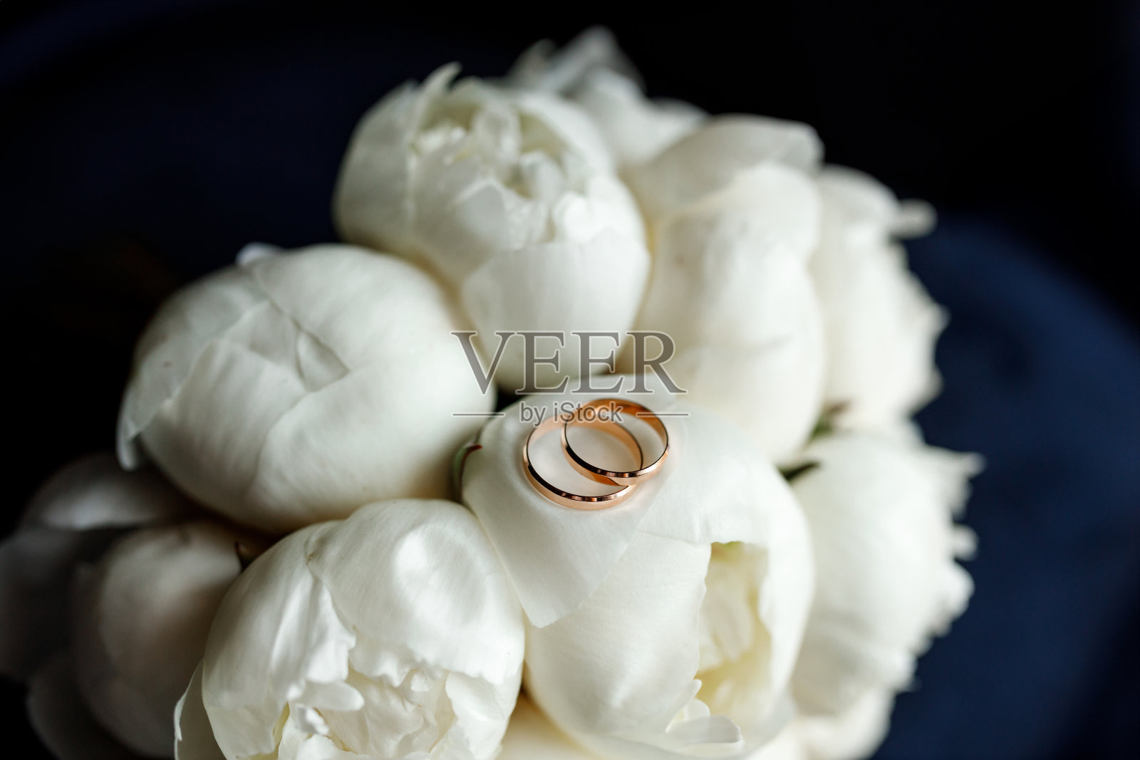 新娘的白牡丹花束和结婚戒指照片摄影图片