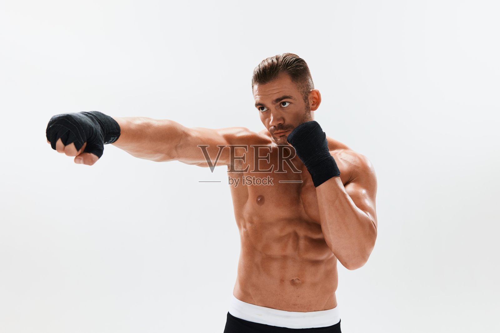 男子健美运动员摆姿势，在拳击手套与躯干腹肌在全长背景，拳击和武术。广告，运动，积极的生活方式，竞争，挑战的理念。照片摄影图片