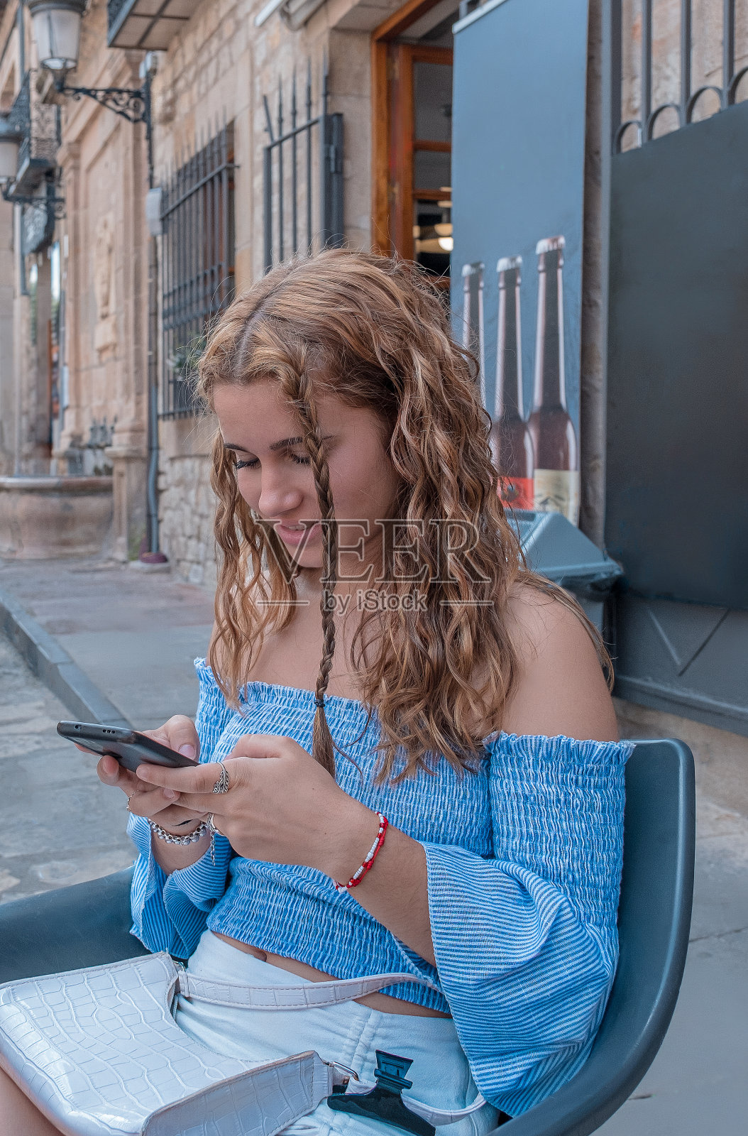 年轻的女孩用她的手机娱乐。照片摄影图片