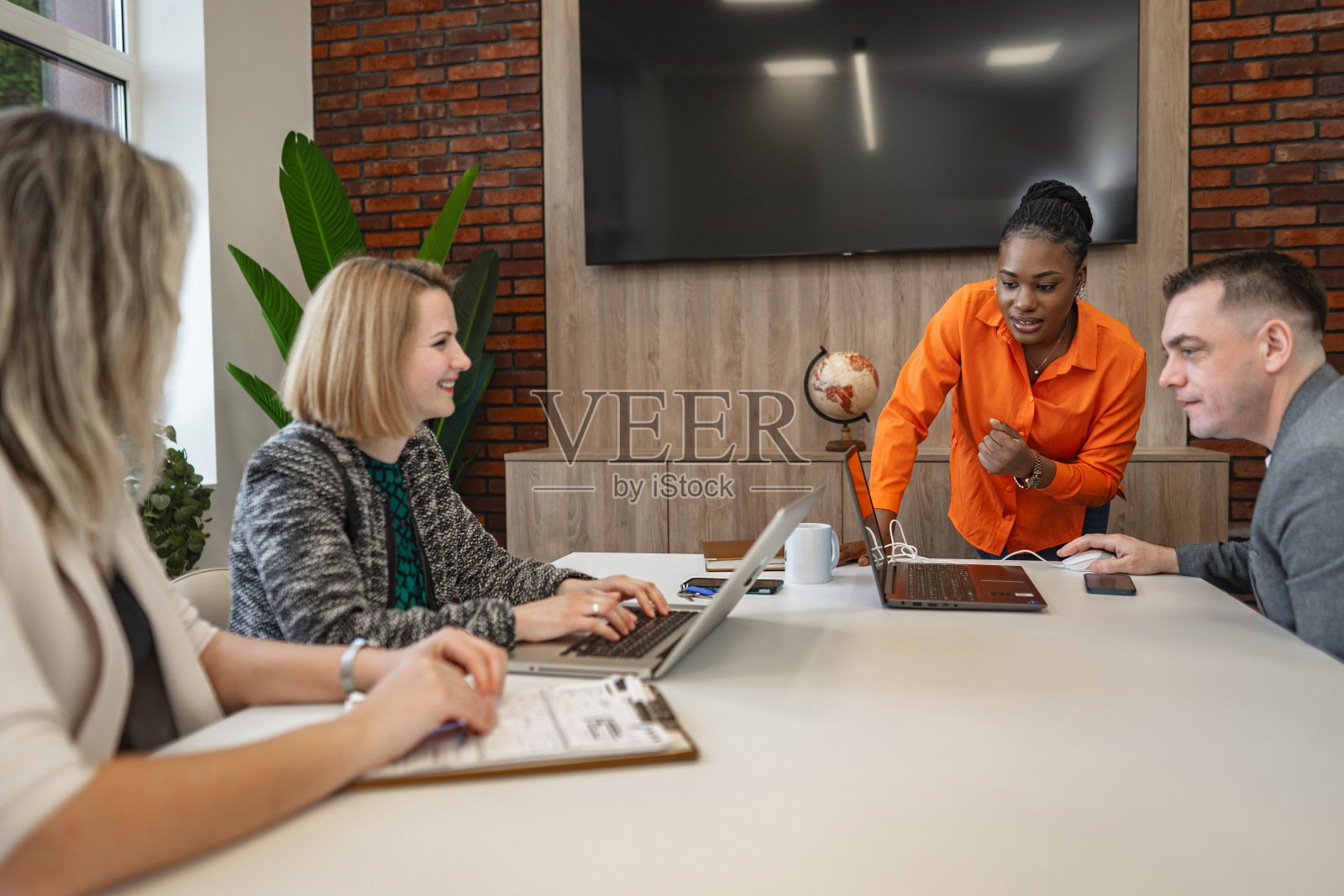 黑人女商人在办公室开会时与她的团队谈话照片摄影图片