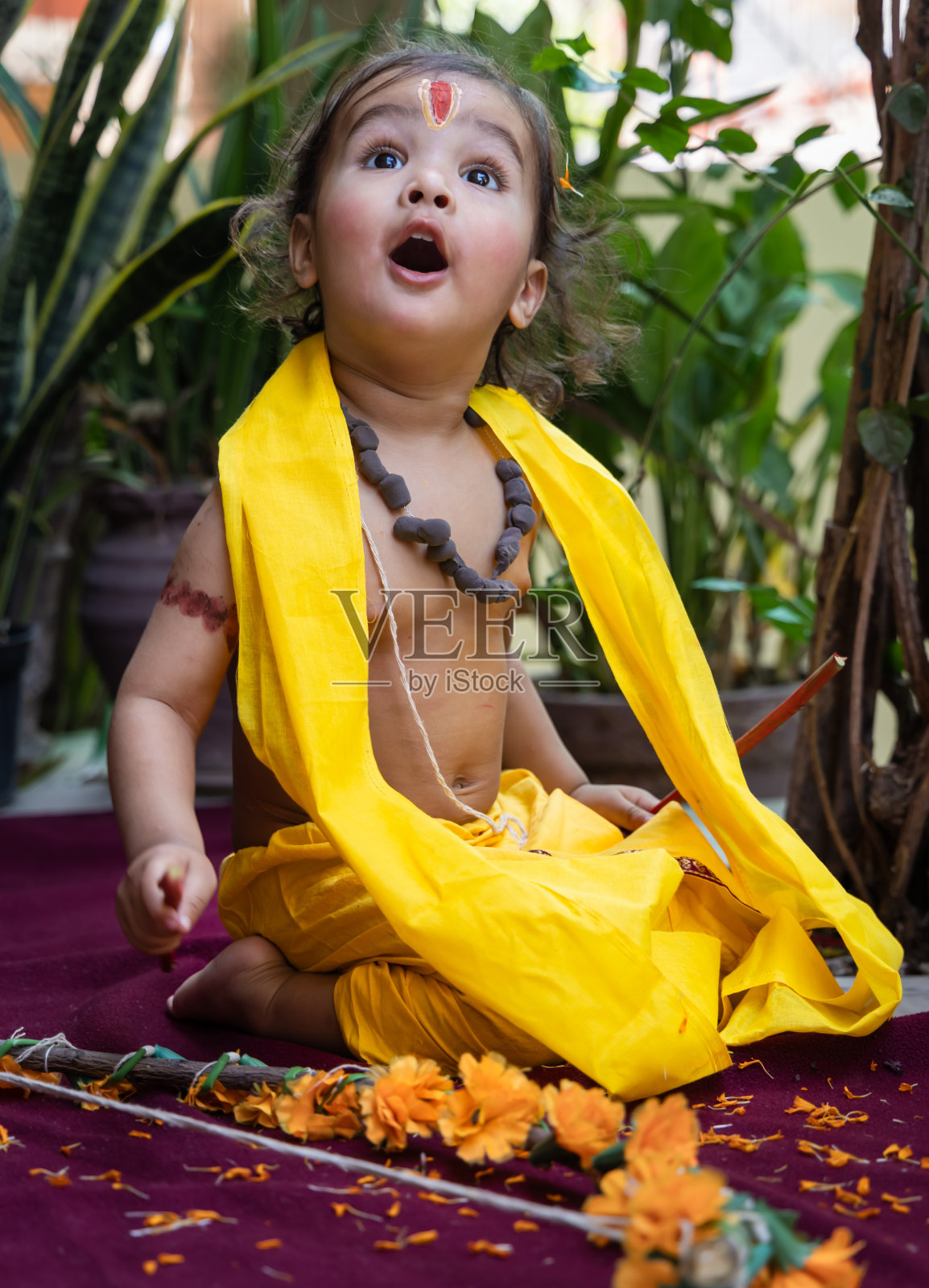 可爱的印度男孩在户外穿着罗摩王的衣服，白天背景模糊照片摄影图片