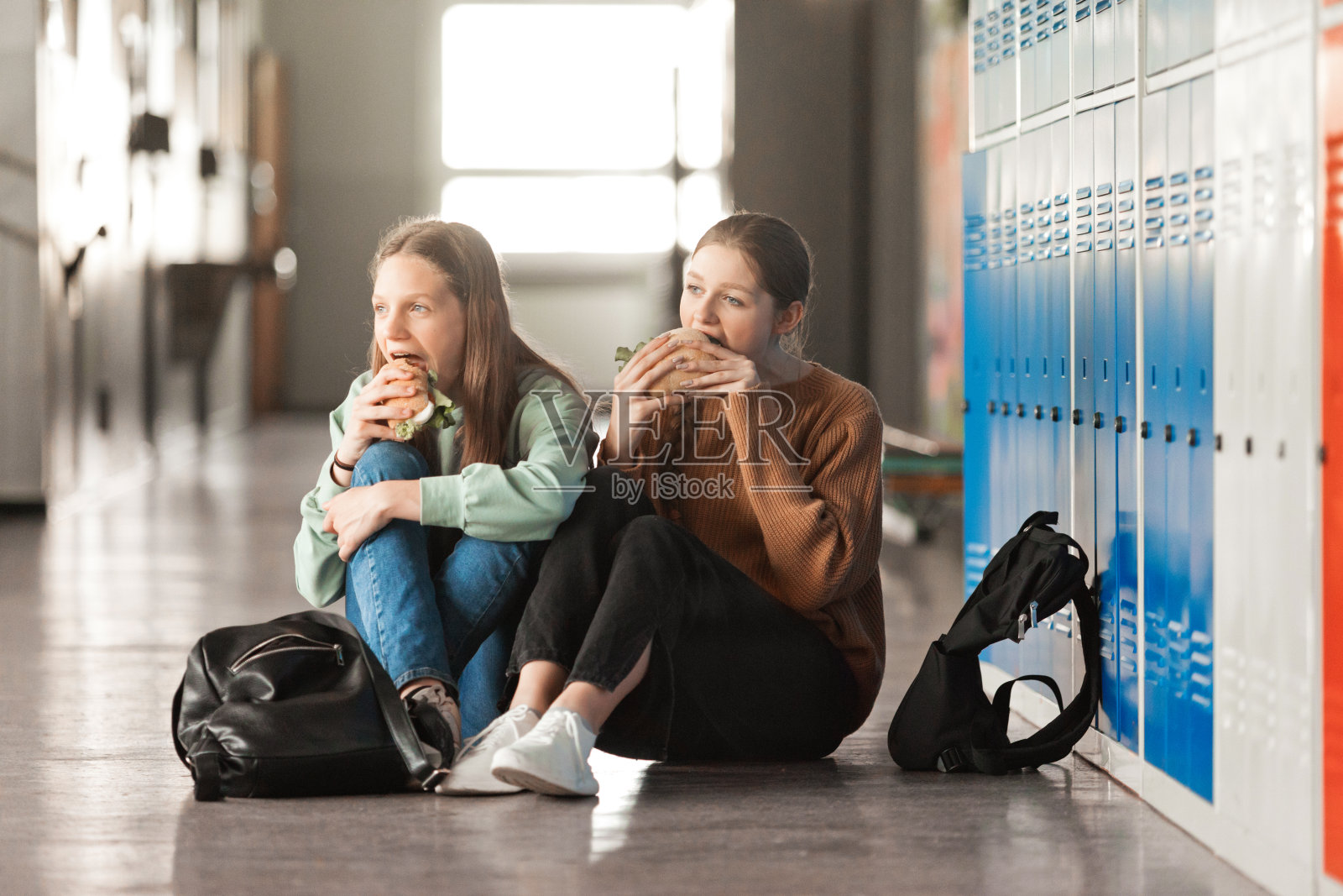 少女们在学校走廊吃三明治照片摄影图片