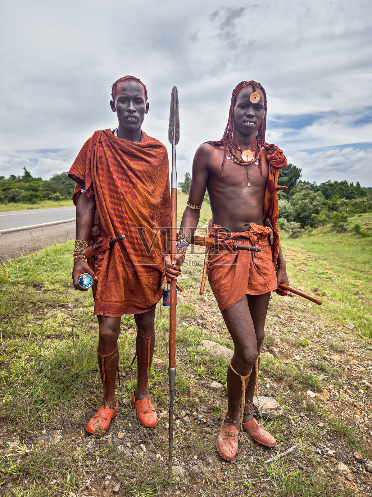 在肯尼亚马赛马拉国家保护区附近的道路上，穿着传统彩色服装的马赛人照片摄影图片