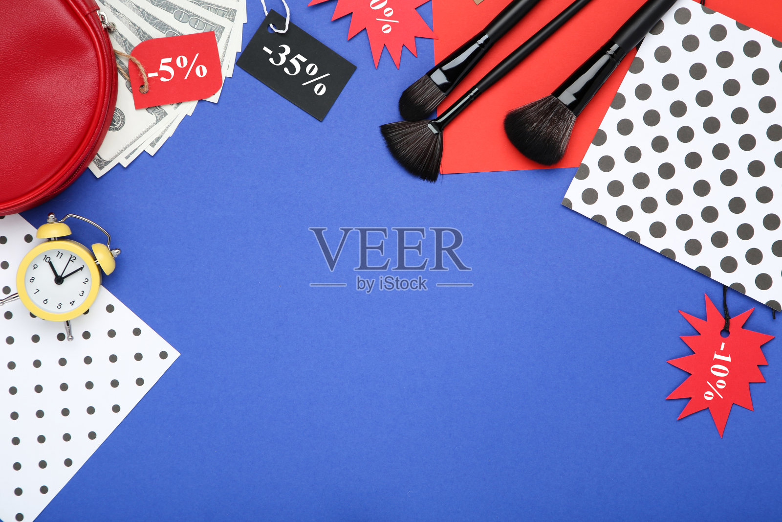 化妆刷与化妆袋，闹钟和标签在蓝色背景照片摄影图片