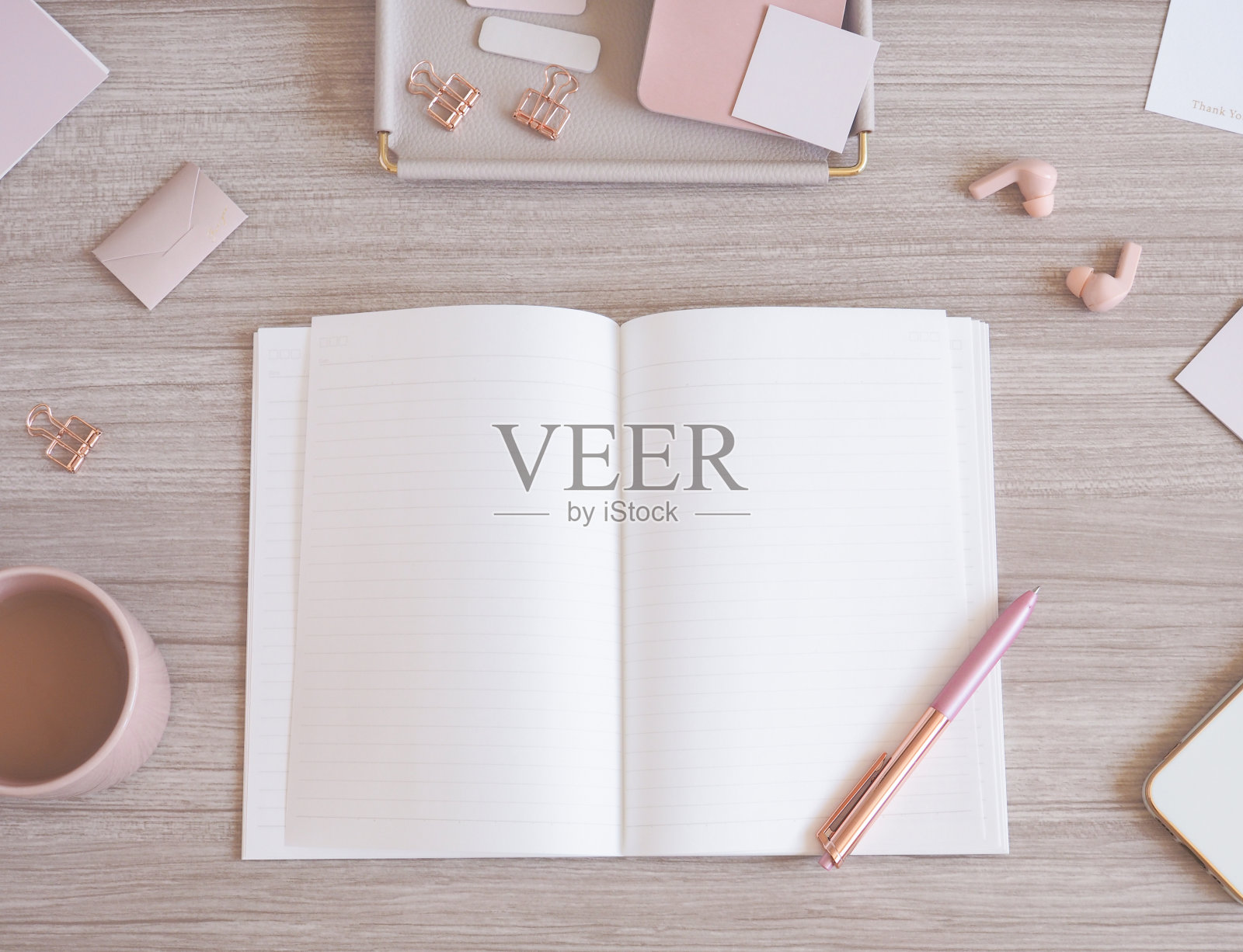 轻木纹和粉米色的柔美桌面俯视图，营造出女性化的工作空间照片摄影图片