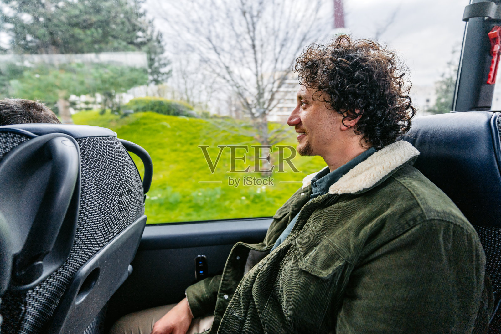 在法国巴黎，一个年轻人坐在公共汽车上照片摄影图片