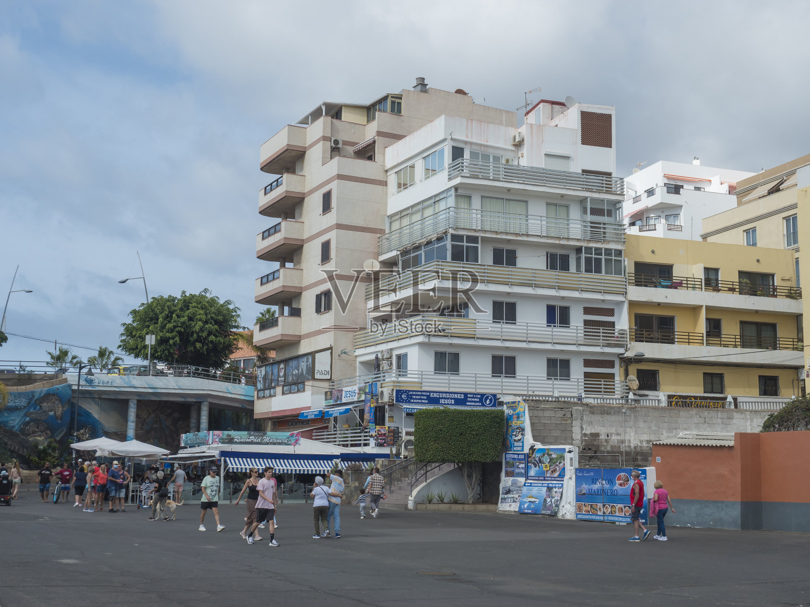 街道上有旅游商店、餐馆和行人。洛斯克里斯蒂亚诺斯是特内里费岛的热门度假胜地。阳光明媚的圣诞节。照片摄影图片