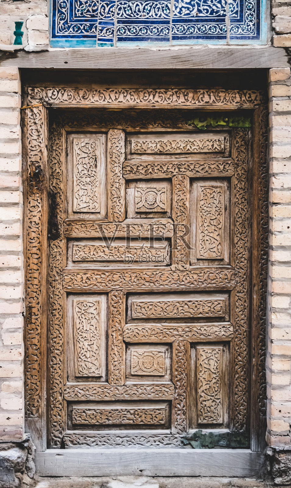 乌兹别克斯坦希瓦古城的一扇有图案和装饰的古木门，木雕照片摄影图片
