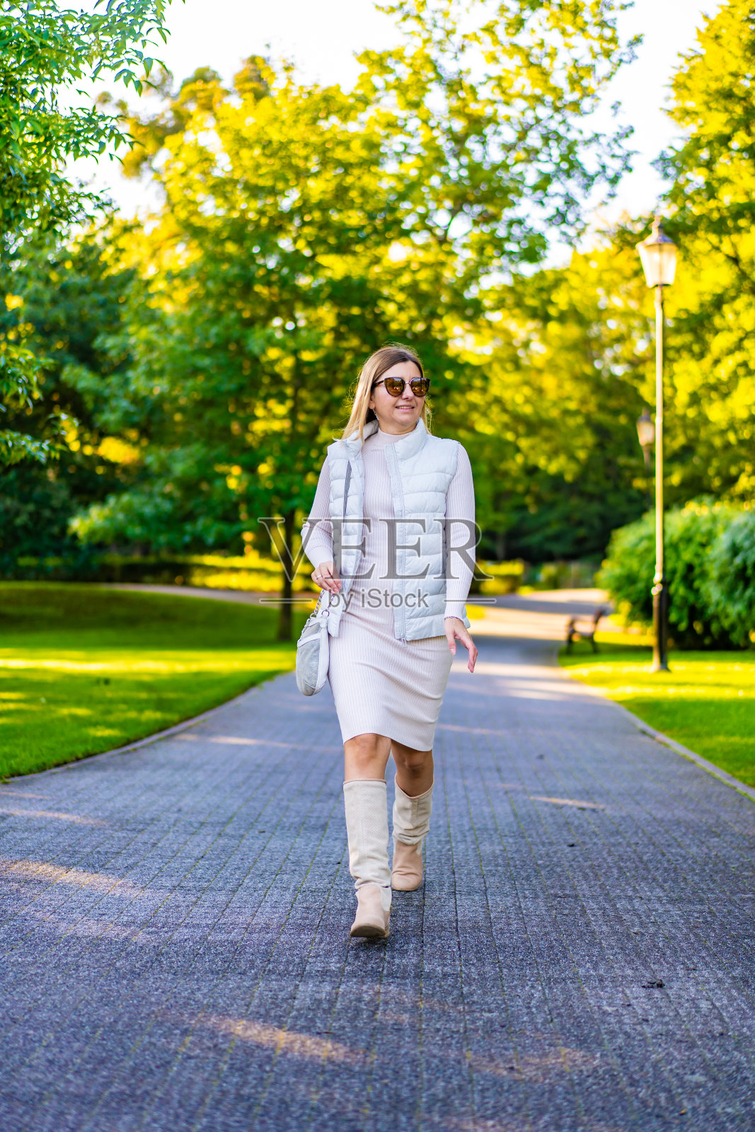 美丽的中年女子在城市公园散步照片摄影图片