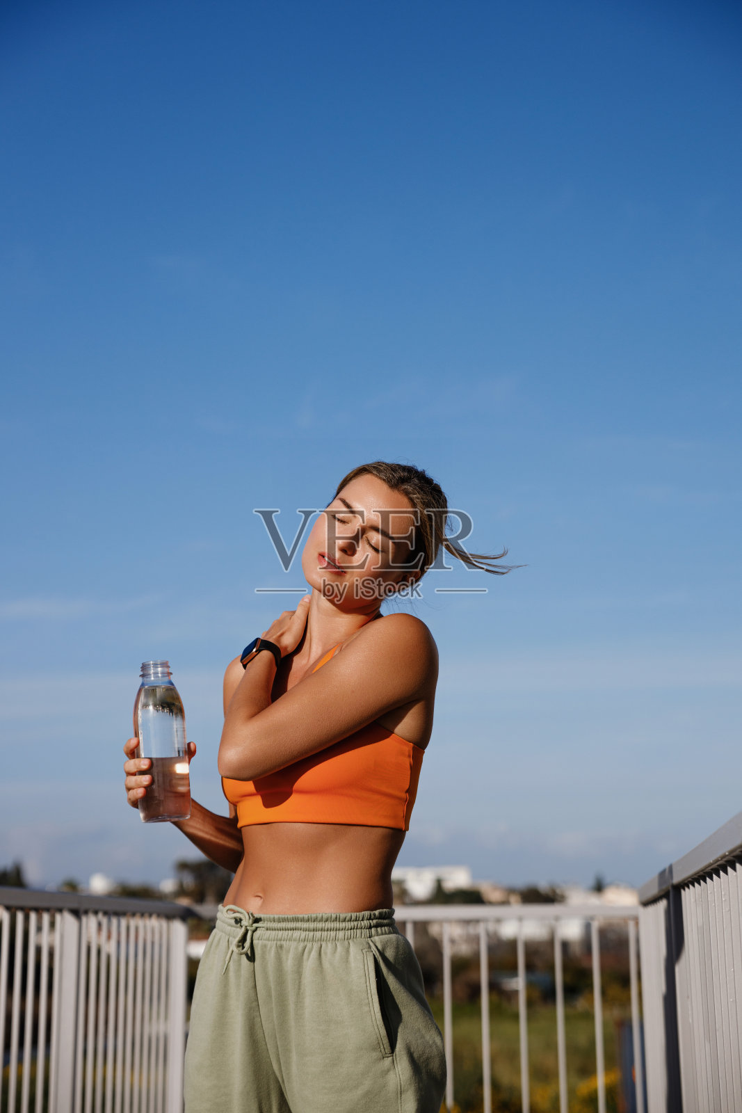 年轻女子在锻炼后喝了一杯清爽的水照片摄影图片