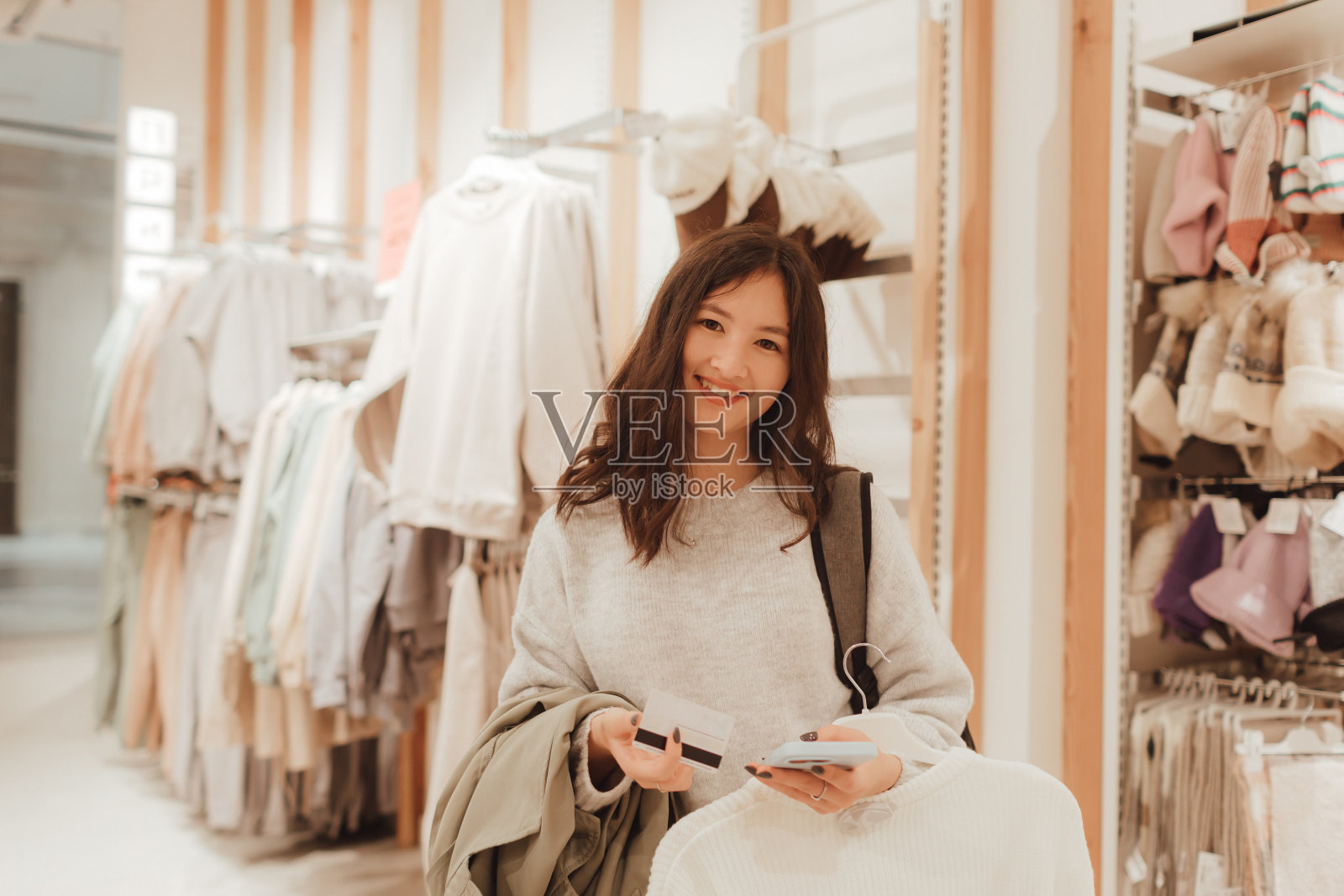 一个十几岁的女孩手里拿着信用卡，想在购物中心买新衣服。零售和消费主义。促销和购物理念。系列的一部分照片摄影图片