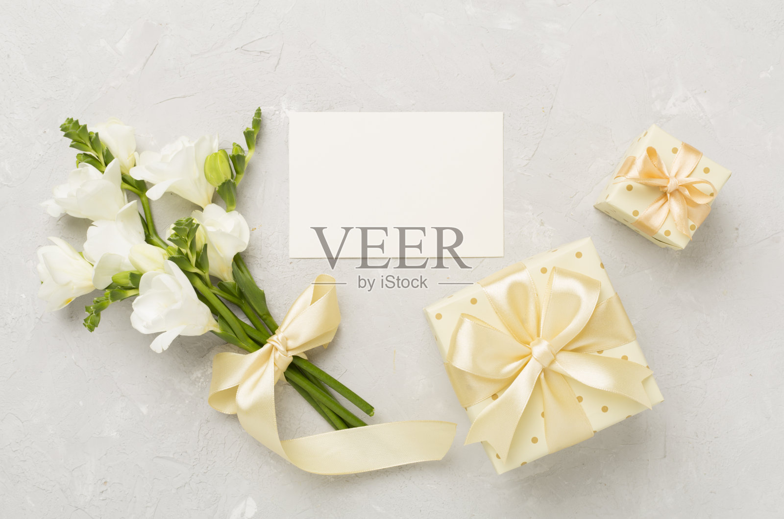 礼盒与小苍兰花混凝土背景，顶视图照片摄影图片