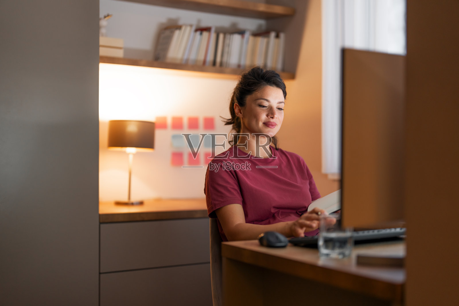 一个有奉献精神的成年女性在家工作，使用电脑照片摄影图片