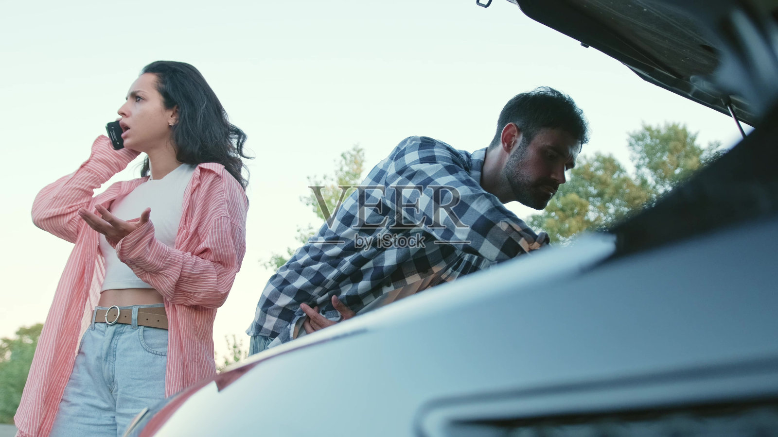 一名愤怒的女子在路上的破损汽车附近打电话给保险公司。慢动作照片摄影图片