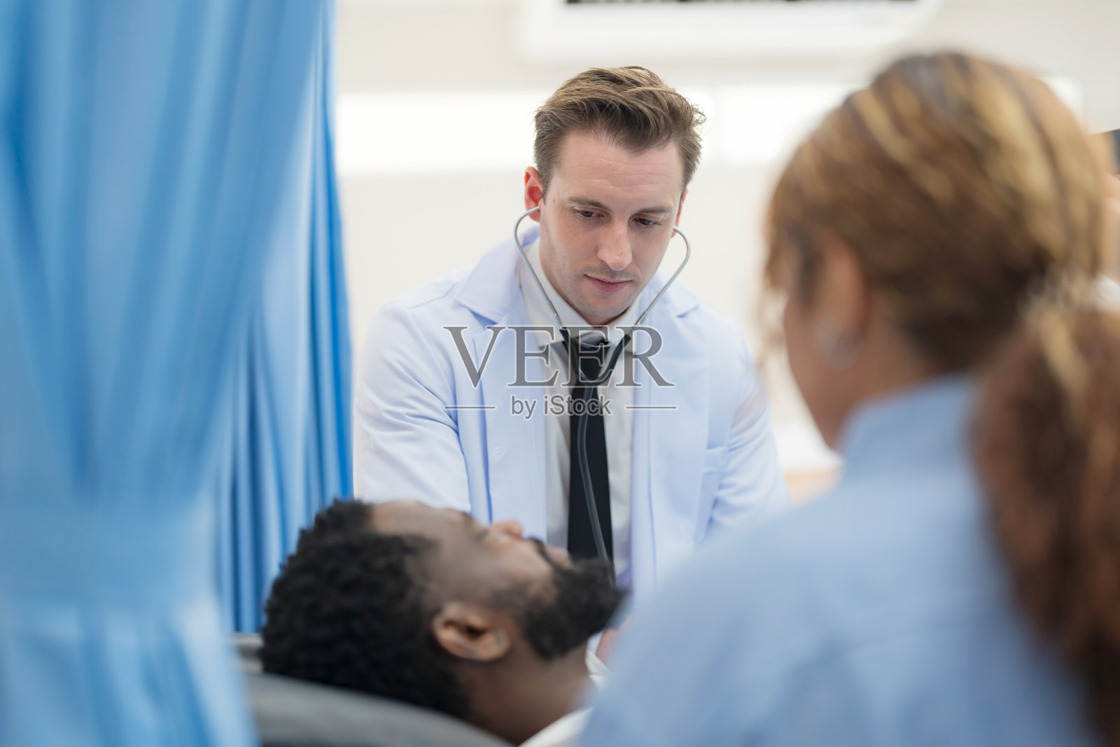 医生正在检查男性的心率。照片摄影图片