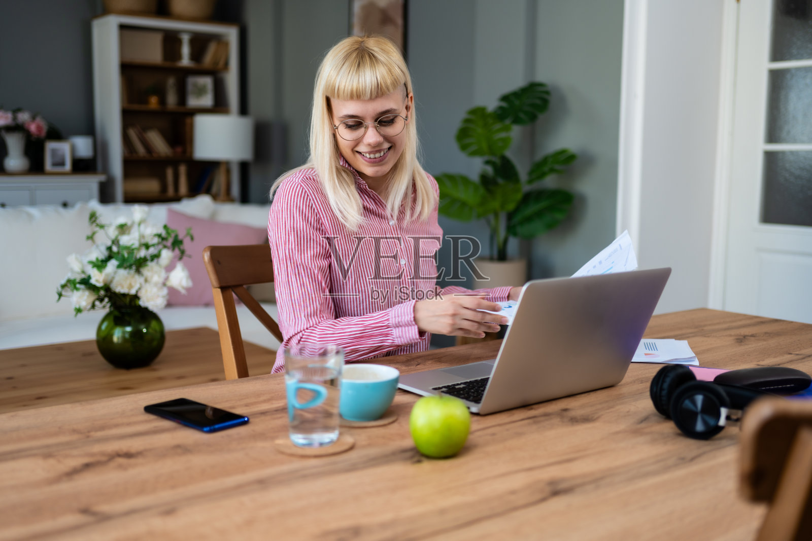 年轻生病的自由职业女性在家工作，在笔记本电脑上工作。在线远程办公，女公司无线连接，做远程财经修改。电子商务照片摄影图片