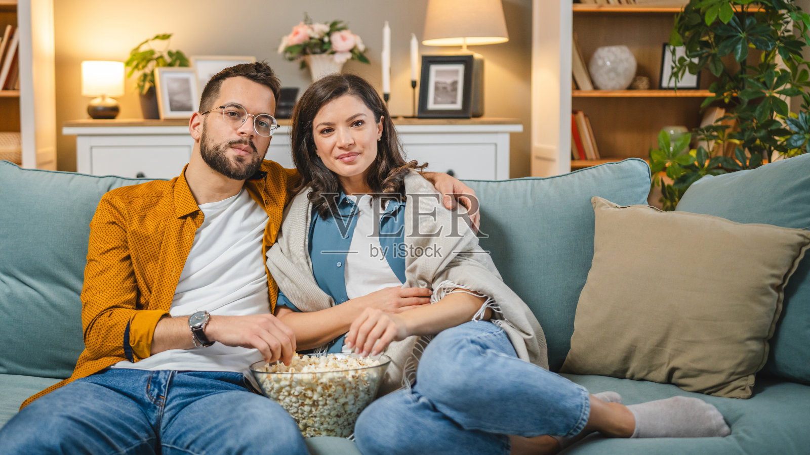 一对白人男女坐在家里的沙发床上看电视电影照片摄影图片