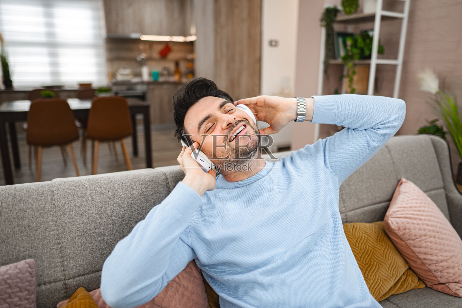 戴着无线耳机的帅哥在客厅里听音乐照片摄影图片