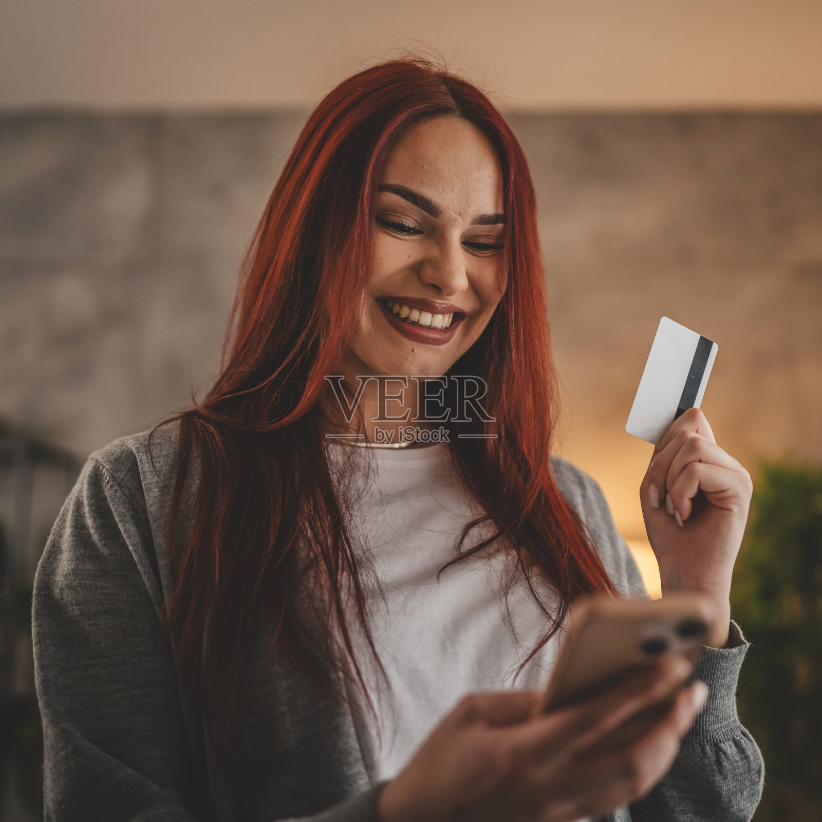 年轻女子白种女性持信用卡在家网上购物照片摄影图片