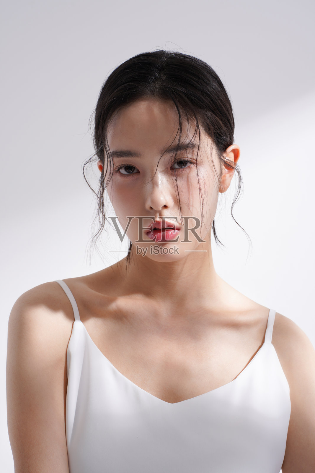 一个年轻的韩国女性在光影背景下拍摄的美丽形象照片摄影图片