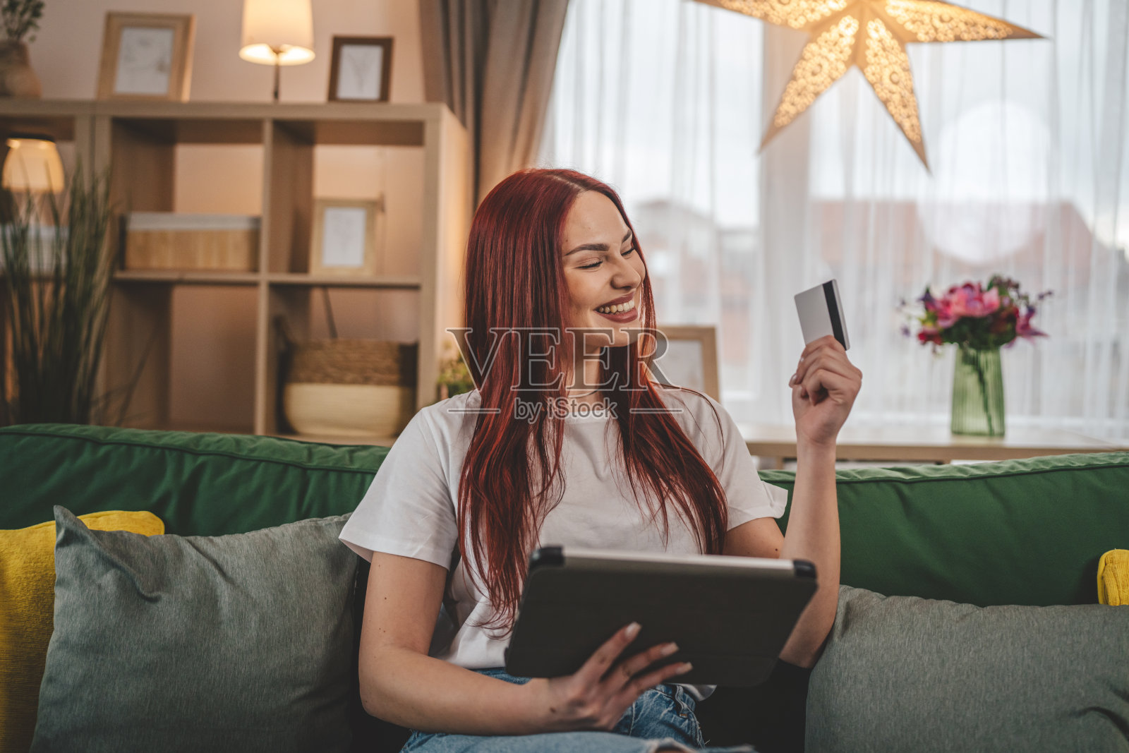 年轻女子白种女性持信用卡在家网上购物照片摄影图片