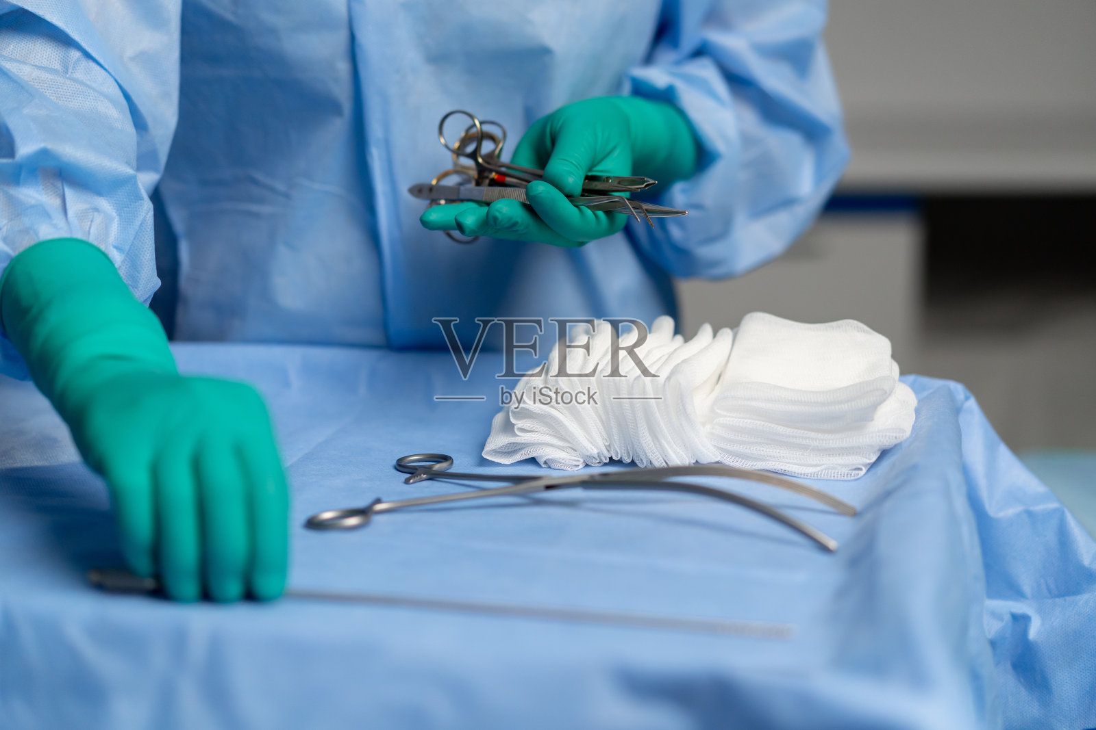 近距离观察手术室，绿色手套在手术床头柜上摆放着器械照片摄影图片