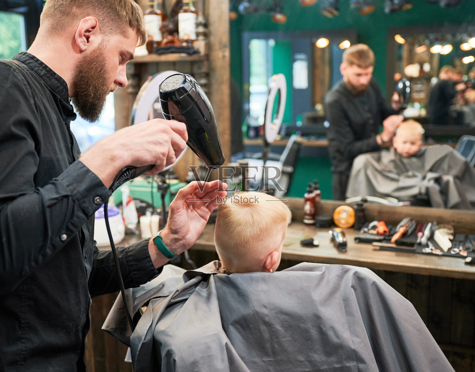 有能力的理发师为新发型造型。照片摄影图片