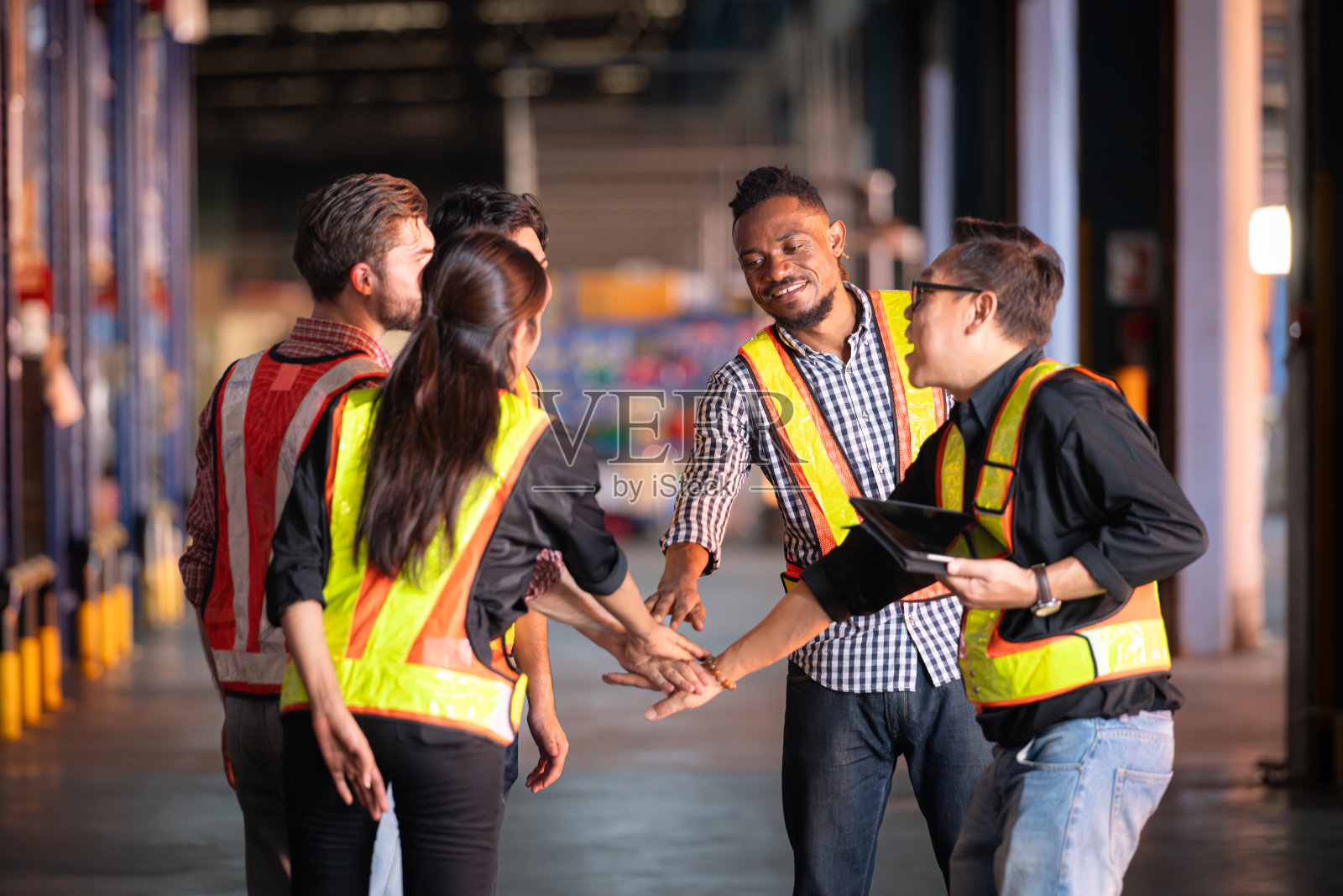 一群仓库员工，在产品被送到零售商之前检查仓库货架上的产品照片摄影图片