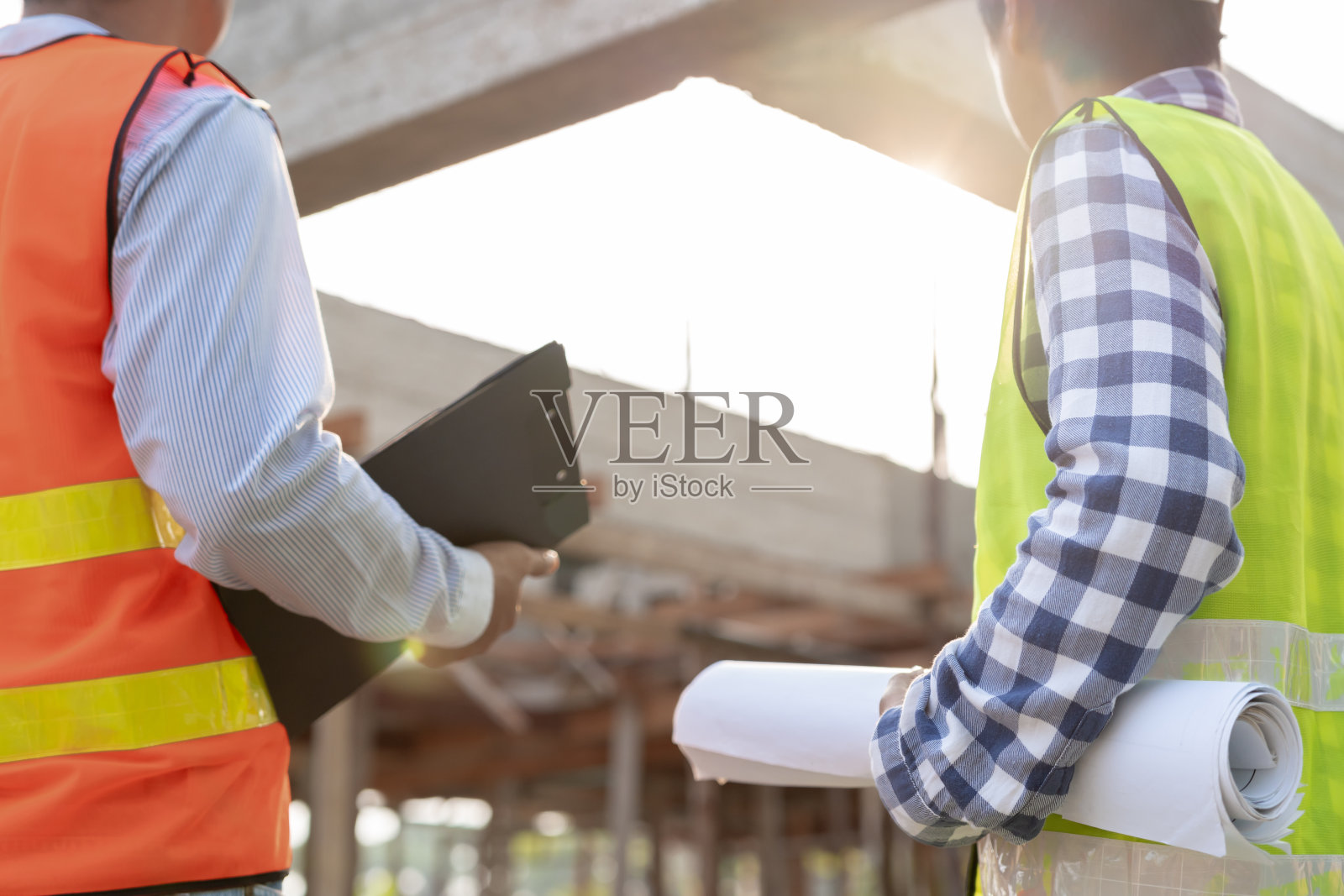 检验员或工程师正在使用蓝图检查建筑和质量保证新房。工程师或建筑师或承包商在把房子交给房主之前先建造房子照片摄影图片