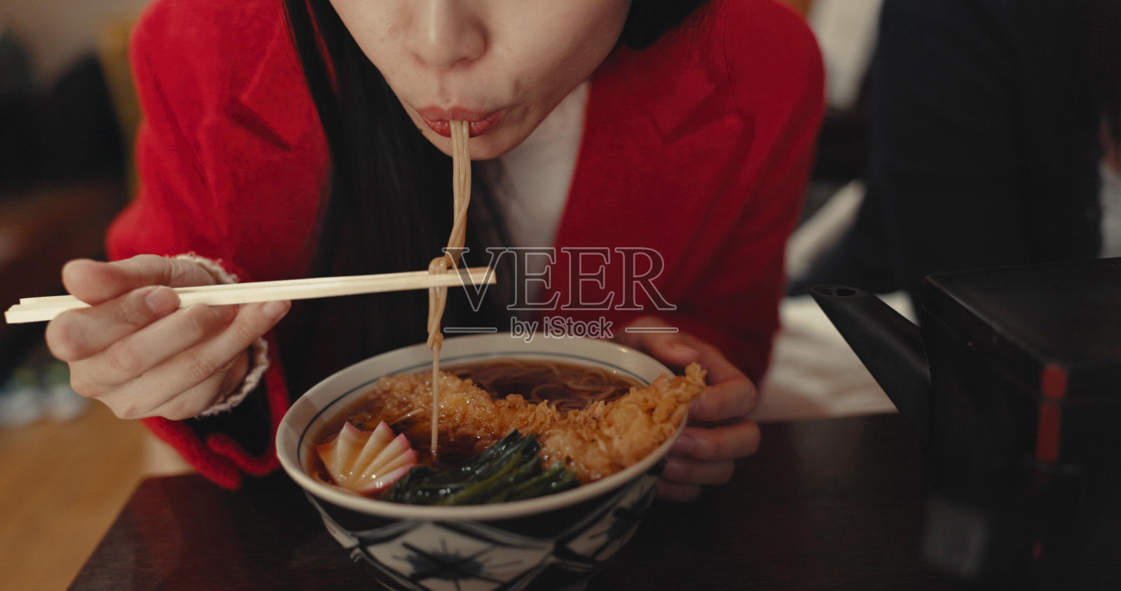 女人，晚餐在饭店吃拉面，在食堂吃正餐和面条。特写，饥肠辘辘的女士拿着筷子在快餐店吃意大利面、日本料理和午餐照片摄影图片