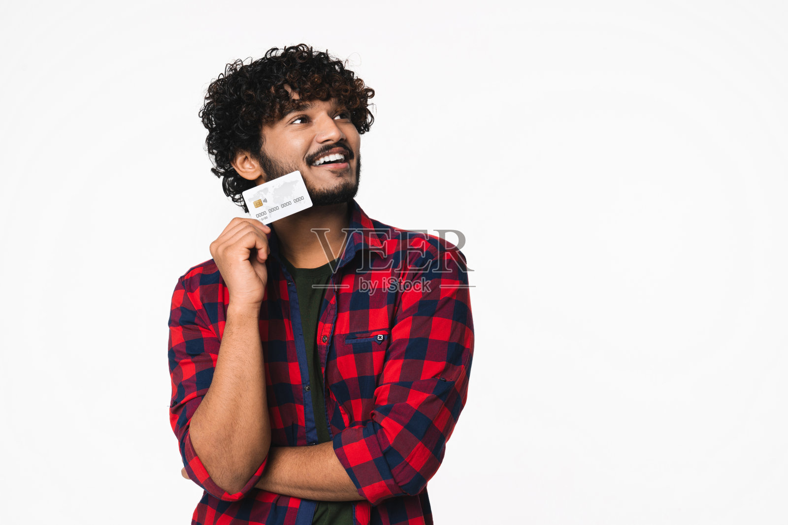 沉思的年轻印度男子考虑用信用卡购物孤立照片摄影图片